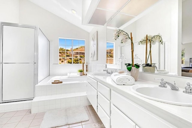full bath with tile patterned flooring, a sink, a bath, and vaulted ceiling