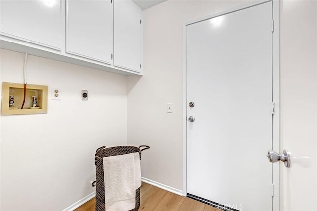washroom with hookup for an electric dryer, cabinet space, baseboards, hookup for a washing machine, and light wood-style floors
