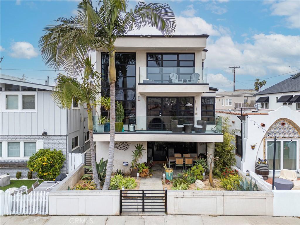 179 Santa Ana Ave, Long Beach, CA 90803 - view of front of home with stucco siding, a fenced front yard, a gate, and a balcony