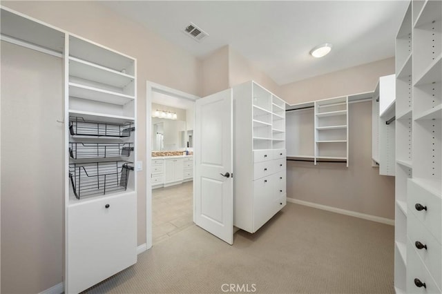 spacious closet featuring light colored carpet and visible vents