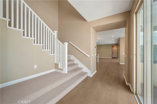 entryway featuring baseboards, recessed lighting, stairs, and wood finished floors