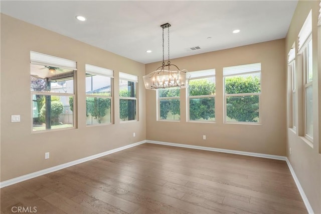 unfurnished dining area featuring baseboards, hardwood / wood-style flooring, and a wealth of natural light
