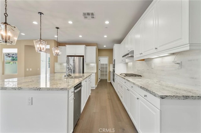 kitchen with visible vents, recessed lighting, under cabinet range hood, light wood finished floors, and appliances with stainless steel finishes