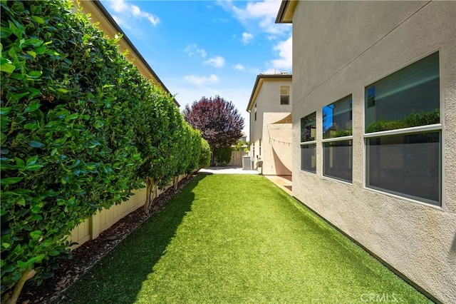 view of yard featuring a fenced backyard and central AC