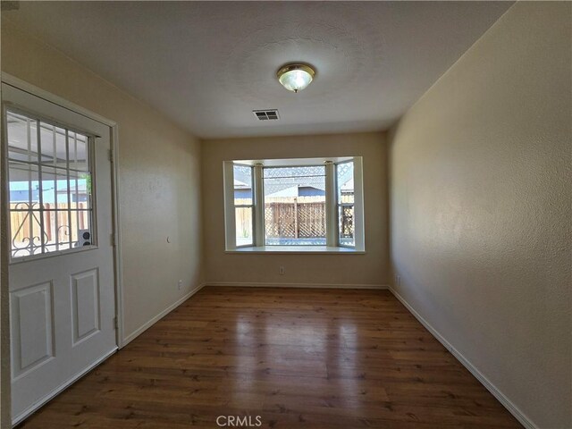 interior space with visible vents, baseboards, and wood finished floors