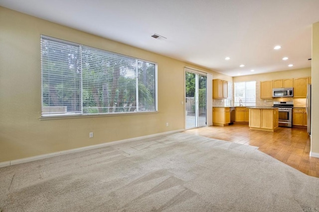 kitchen with light carpet, baseboards, open floor plan, recessed lighting, and stainless steel appliances