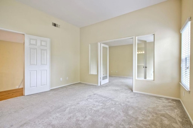 unfurnished room with baseboards, carpet, french doors, and visible vents