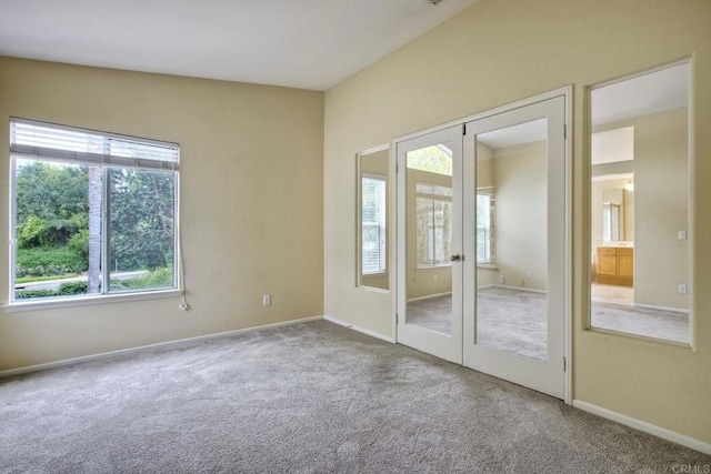 carpeted spare room with baseboards and french doors