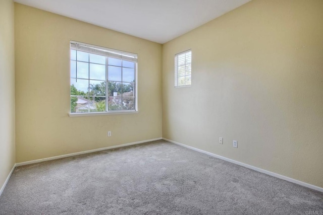 carpeted empty room with baseboards