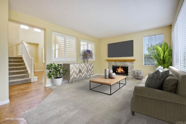 living area featuring baseboards, stairs, wood finished floors, and a wealth of natural light