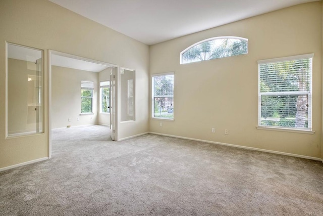 unfurnished room with baseboards and carpet