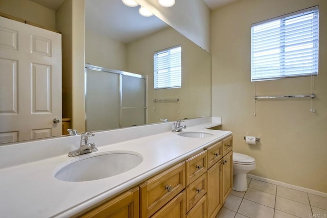 bathroom featuring double vanity, tile patterned floors, a sink, and a stall shower