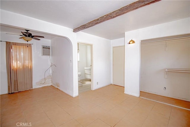 66365 5th St, Desert Hot Springs, CA 92240 - unfurnished bedroom with beam ceiling, a ceiling fan, a wall unit AC, light tile patterned floors, and a closet