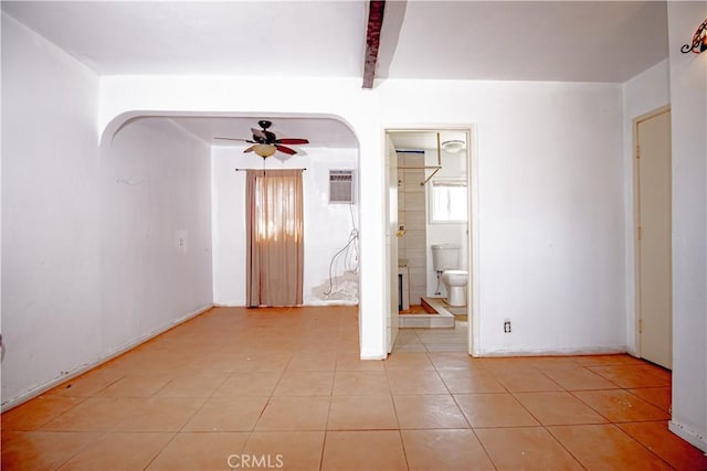 66365 5th St, Desert Hot Springs, CA 92240 - empty room with ceiling fan, arched walkways, a wall mounted AC, beamed ceiling, and light tile patterned flooring