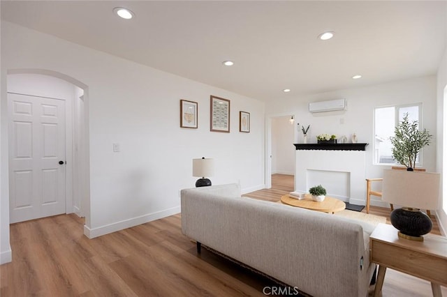 11714 S Spring St, Los Angeles, CA 90061 - living area featuring an AC wall unit, arched walkways, light wood-style floors, and recessed lighting