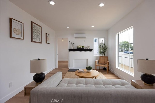 11714 S Spring St, Los Angeles, CA 90061 - living area with recessed lighting, baseboards, a wall mounted AC, and light wood-style flooring