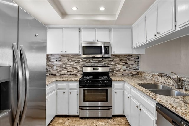 680 Grand Ave Unit 105, Long Beach, CA 90814 - kitchen with white cabinets, appliances with stainless steel finishes, a sink, a raised ceiling, and decorative backsplash
