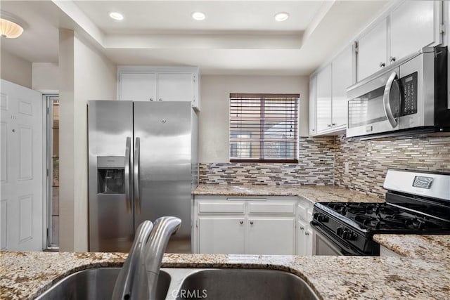680 Grand Ave Unit 105, Long Beach, CA 90814 - kitchen featuring backsplash, stainless steel appliances, light stone countertops, and white cabinetry