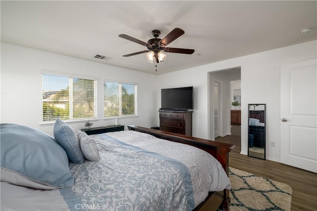 bedroom with baseboards, ceiling fan, wood finished floors, and visible vents