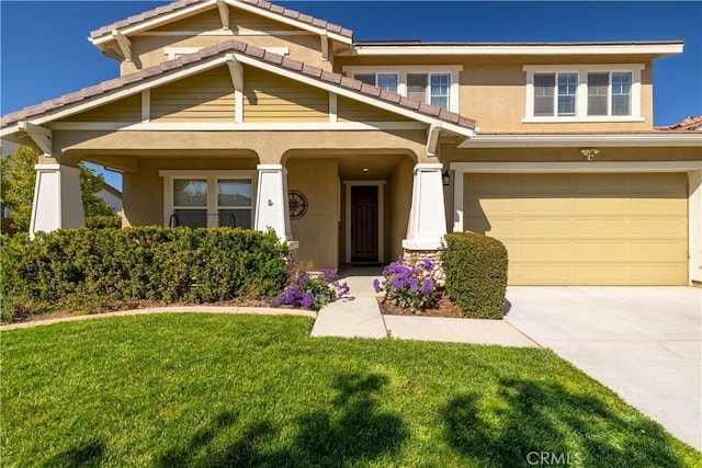 view of front of property featuring a garage, stucco siding, a front yard, a tiled roof, and driveway