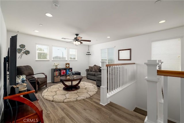 living area featuring a ceiling fan, baseboards, recessed lighting, and wood finished floors