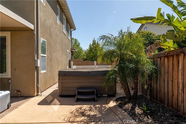 view of patio featuring a hot tub and a fenced backyard