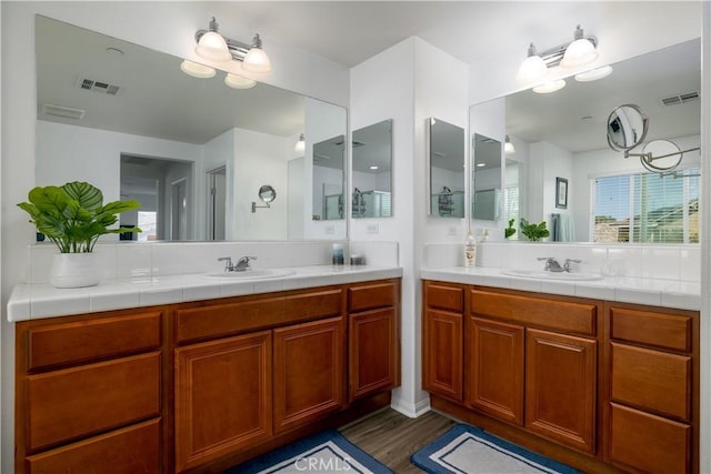 full bath featuring a sink, wood finished floors, and visible vents