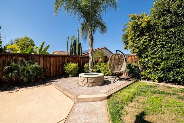 view of yard with a fenced backyard, a patio area, and a fire pit