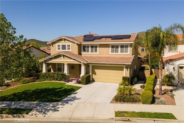 view of front of home featuring a tile roof, a garage, stucco siding, roof mounted solar panels, and concrete driveway