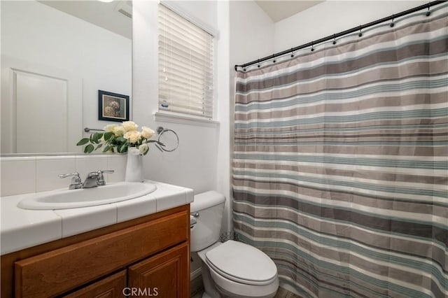 bathroom with vanity, a shower with shower curtain, and toilet