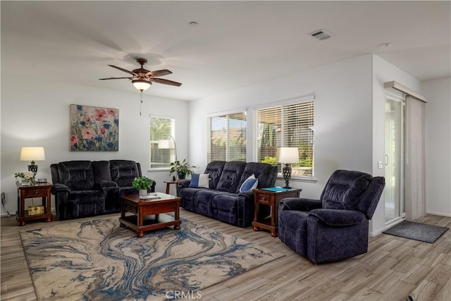 living room featuring ceiling fan, visible vents, and light wood finished floors