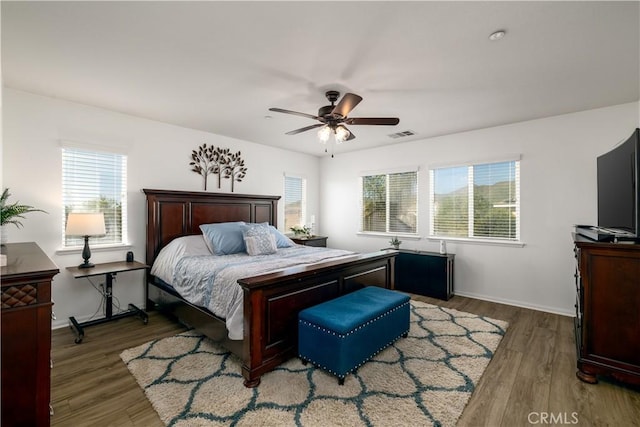 bedroom with multiple windows and light wood-type flooring