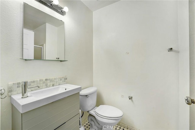 bathroom with backsplash, toilet, tile patterned flooring, and vanity