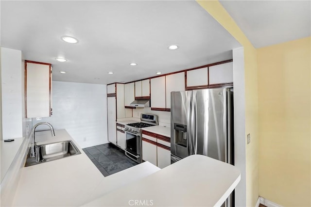 kitchen featuring light countertops, stainless steel appliances, recessed lighting, and a sink