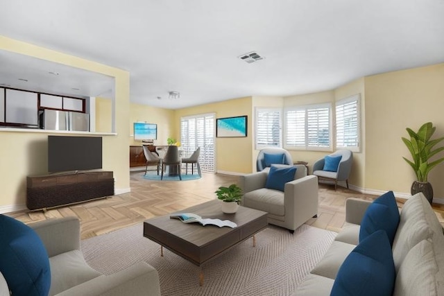 living room featuring baseboards and visible vents