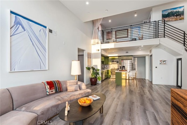 1055 S Serrano Ave Unit 502, Los Angeles, CA 90006 - living area featuring a high ceiling, recessed lighting, baseboards, wood finished floors, and visible vents