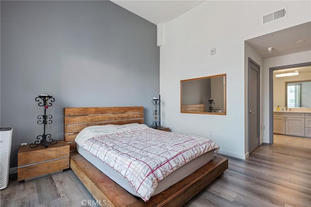 1055 S Serrano Ave Unit 502, Los Angeles, CA 90006 - bedroom with high vaulted ceiling, baseboards, wood finished floors, and visible vents