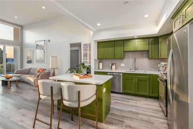 1055 S Serrano Ave Unit 502, Los Angeles, CA 90006 - kitchen featuring green cabinetry, appliances with stainless steel finishes, a sink, light wood-style floors, and light countertops