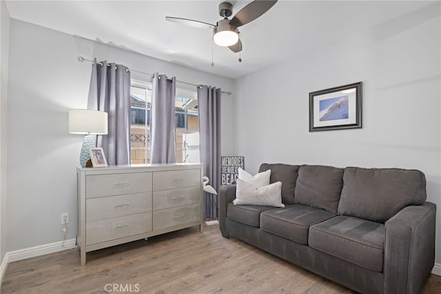 living room featuring baseboards, ceiling fan, and wood finished floors