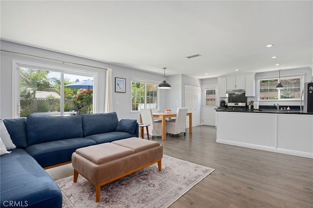 living area with visible vents, recessed lighting, and light wood-style floors