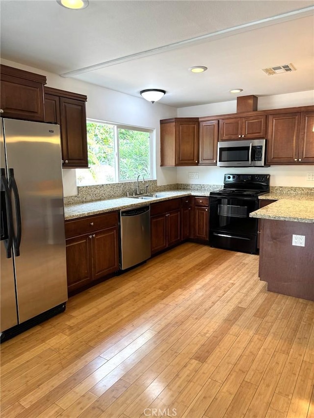 kitchen with visible vents, appliances with stainless steel finishes, light stone countertops, a sink, and recessed lighting