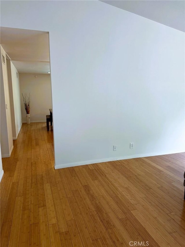 empty room featuring baseboards and light wood-type flooring