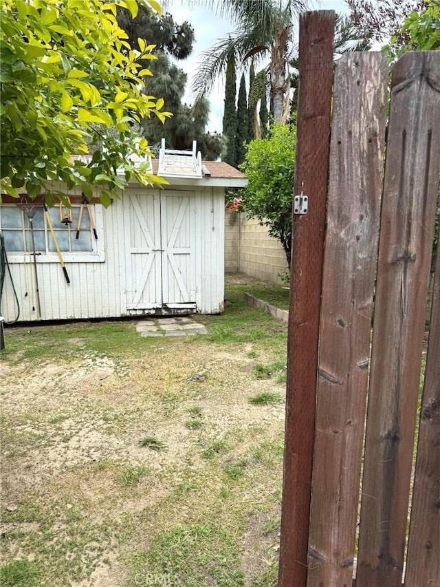 view of yard with an outdoor structure, fence, and a shed