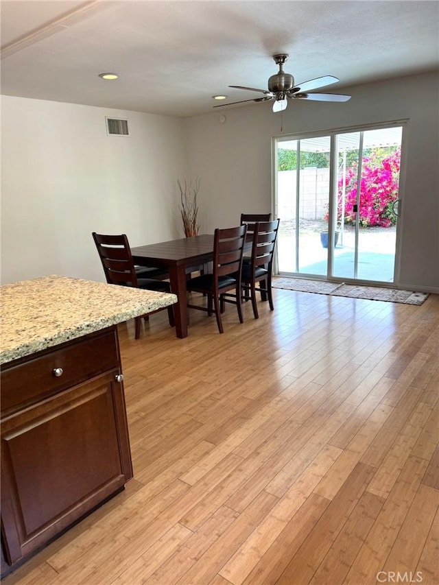 dining area featuring ceiling fan, light wood-type flooring, and visible vents