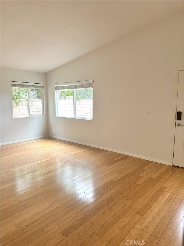 empty room featuring baseboards and light wood finished floors