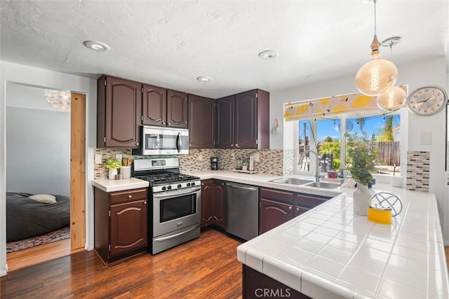 kitchen with a sink, decorative backsplash, stainless steel appliances, and dark wood-type flooring