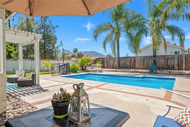 view of swimming pool with a pergola, a patio, a fenced backyard, a fenced in pool, and a mountain view