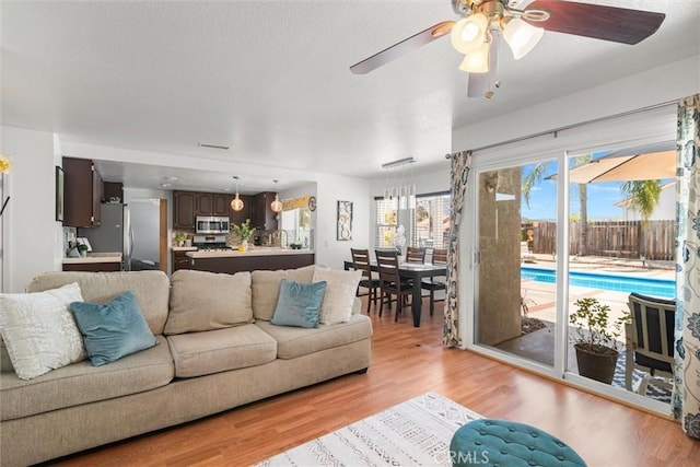 living area featuring a ceiling fan and light wood-style flooring
