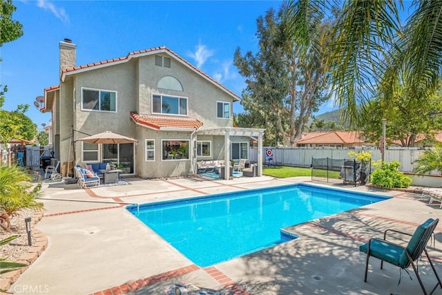back of property with a chimney, a tile roof, a patio area, a pergola, and stucco siding