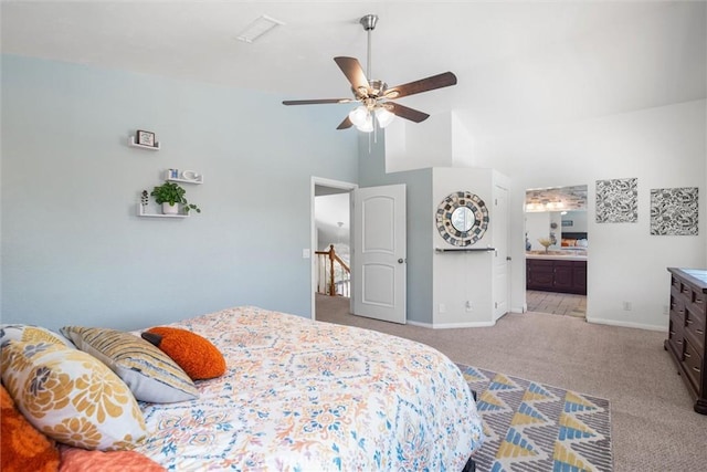 carpeted bedroom featuring ceiling fan, visible vents, baseboards, high vaulted ceiling, and ensuite bath